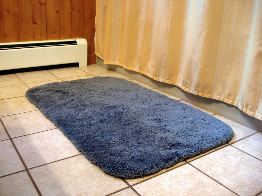 When I step out of the shower, what makes the tile floor so much colder  than the bathroom mat?
